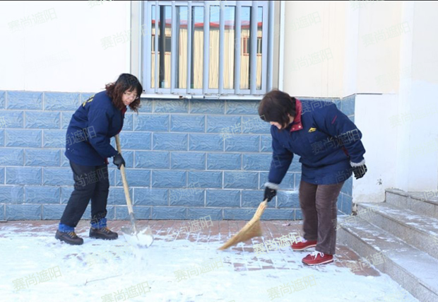 揮舞著鐵鍬和笤帚，相互配合掃雪圖片